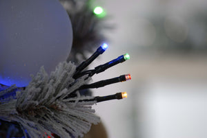 Close up of the bulbs of the 600 multi colour LED string Christmas lights on a flocked tree