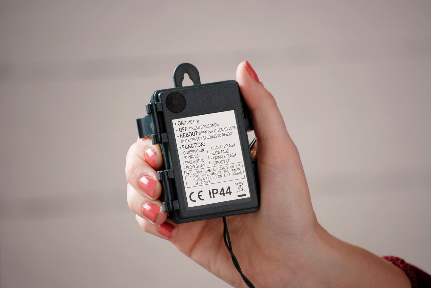 Showing the weatherproof battery pack on the red berries Christmas lights