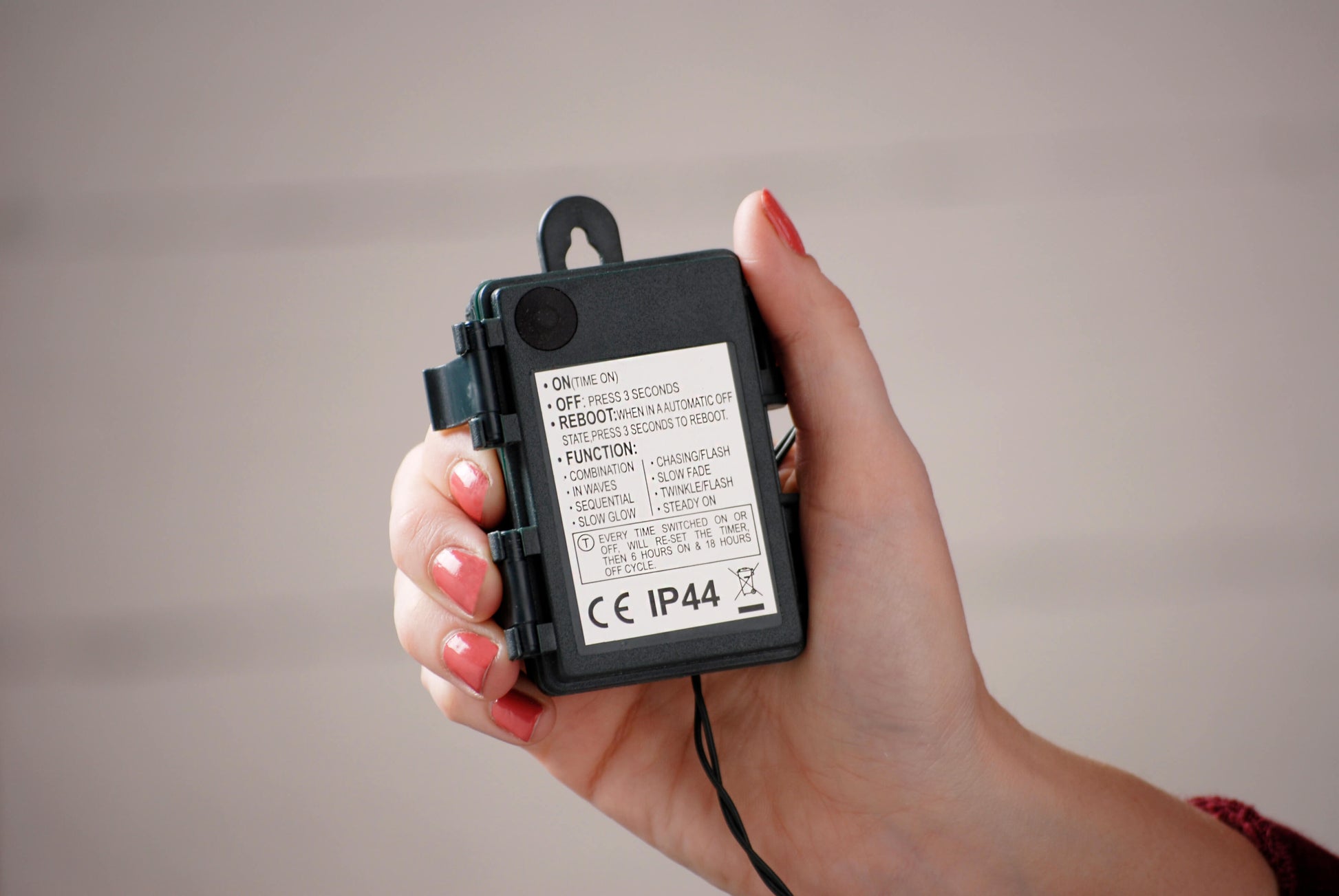 Showing the weatherproof battery pack on the red berries Christmas lights