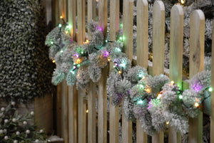 760 pastel tree lights on a Christmas garland, draped over a garden fence