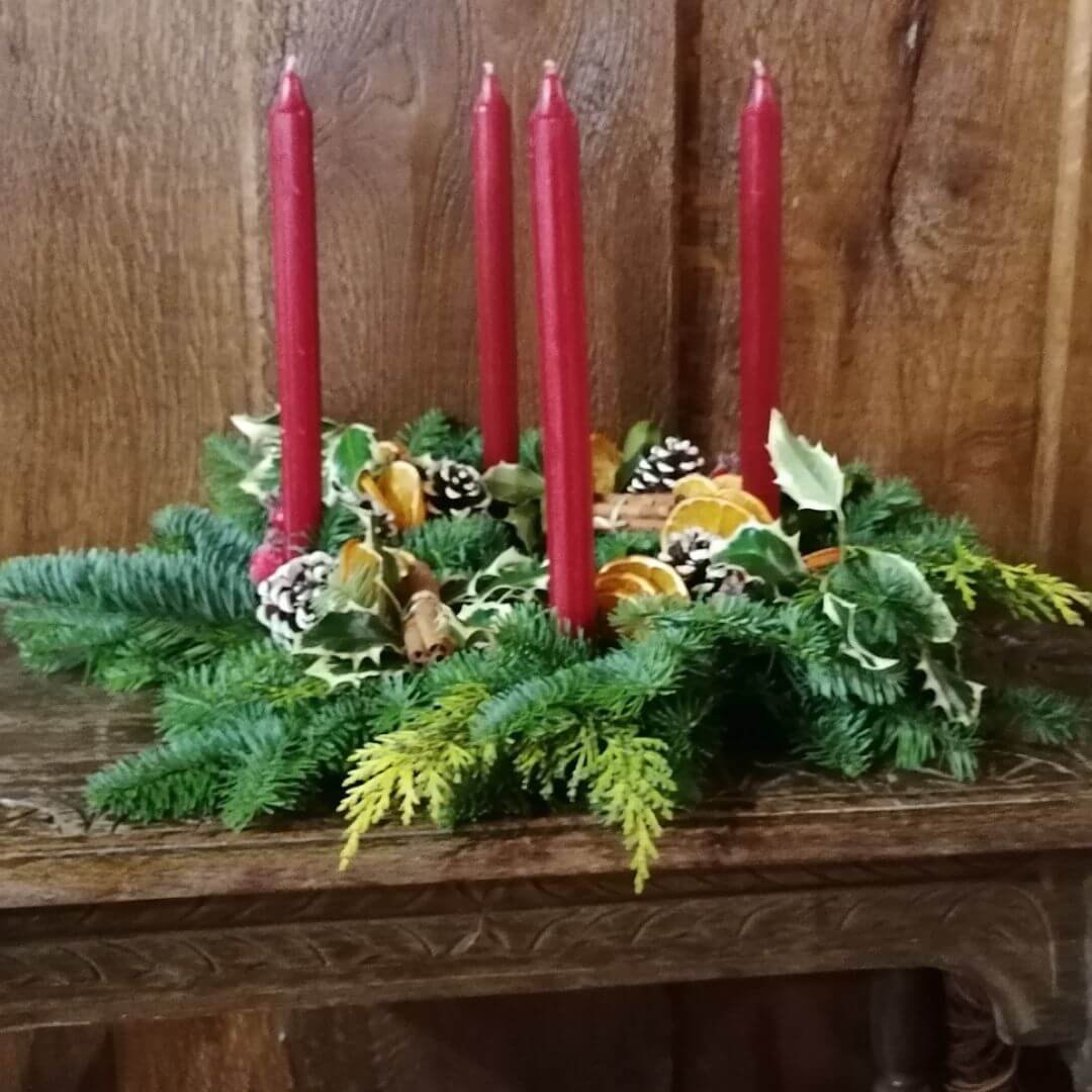 A rustic table centrepiece with burgundy candles