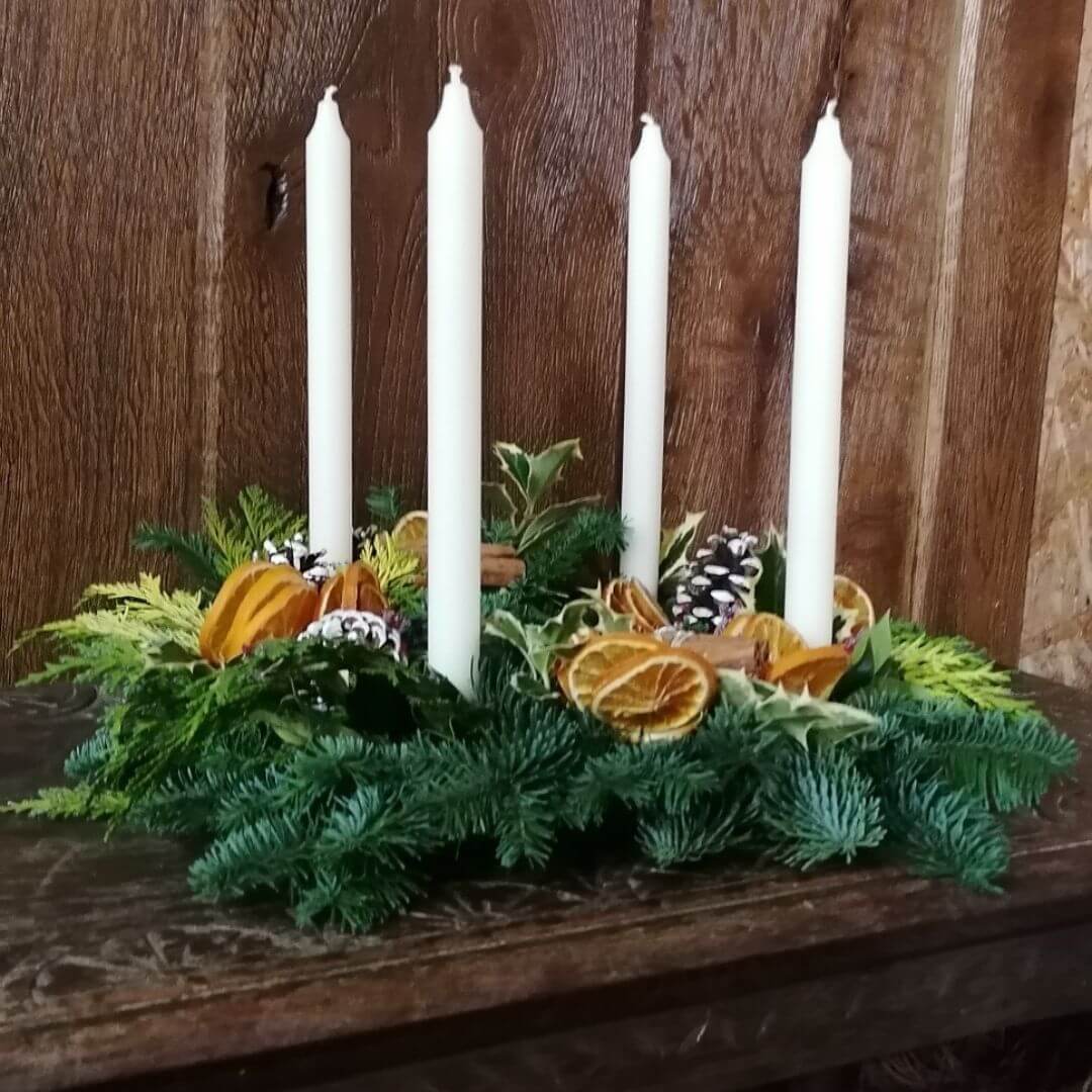 A fresh foliage table centrepiece with ivory candles