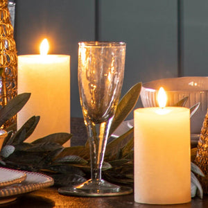 The textured glasses on a dining table laid up with candles either side
