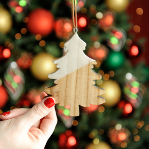 Wooden tree Christmas decorations being held in a hand